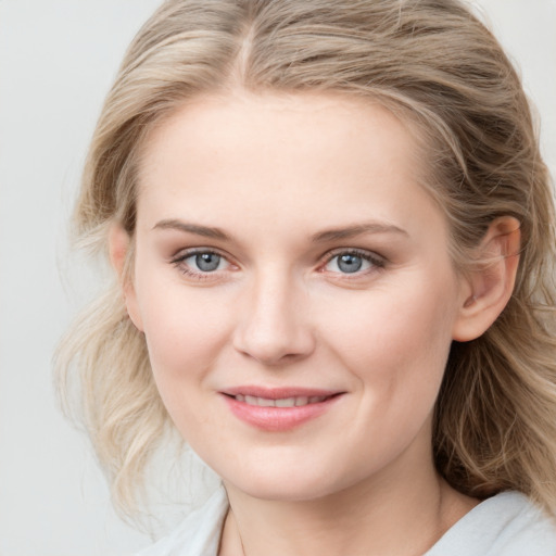 Joyful white young-adult female with medium  brown hair and blue eyes