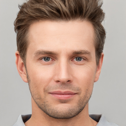 Joyful white young-adult male with short  brown hair and grey eyes