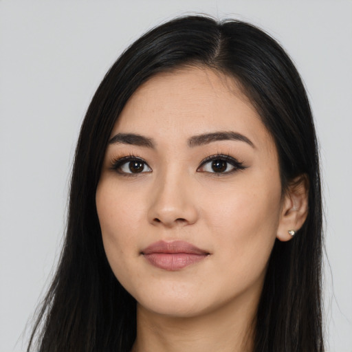 Joyful latino young-adult female with long  black hair and brown eyes