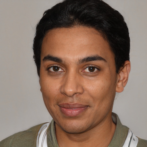 Joyful latino young-adult male with short  black hair and brown eyes