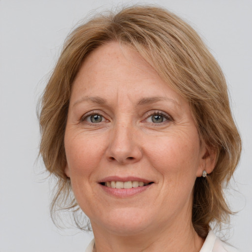 Joyful white adult female with medium  brown hair and blue eyes