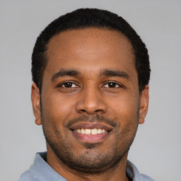 Joyful latino young-adult male with short  black hair and brown eyes