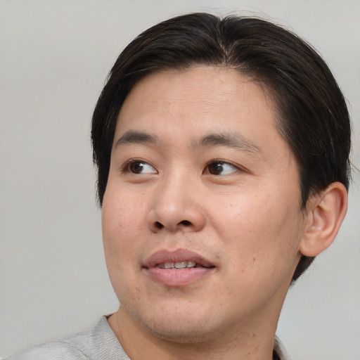 Joyful asian young-adult male with short  brown hair and brown eyes