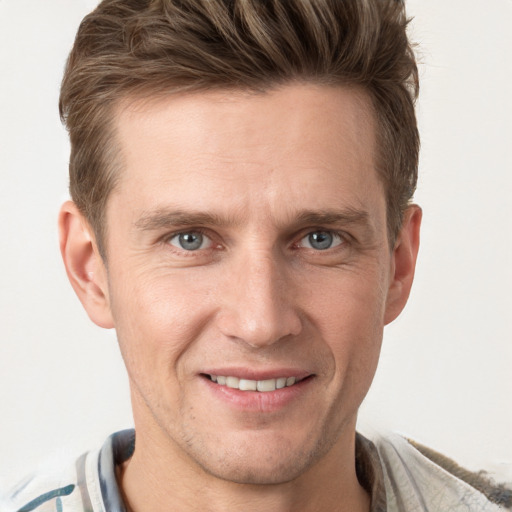 Joyful white young-adult male with short  brown hair and grey eyes