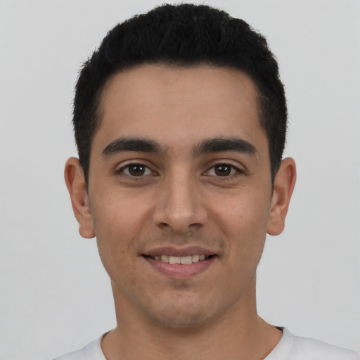 Joyful latino young-adult male with short  black hair and brown eyes