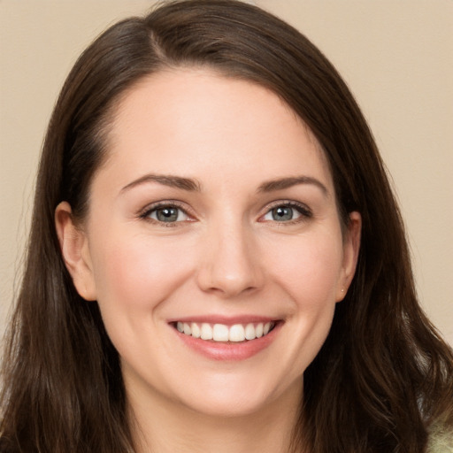 Joyful white young-adult female with long  brown hair and brown eyes