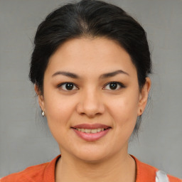 Joyful latino young-adult female with medium  brown hair and brown eyes