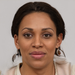 Joyful latino adult female with medium  brown hair and brown eyes