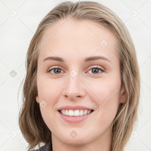 Joyful white young-adult female with long  brown hair and blue eyes