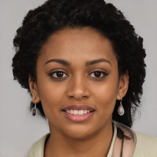 Joyful black young-adult female with long  black hair and brown eyes