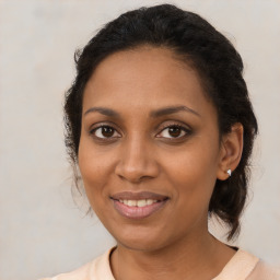 Joyful black adult female with medium  brown hair and brown eyes