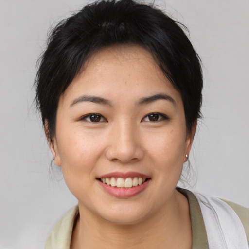 Joyful asian young-adult female with medium  brown hair and brown eyes