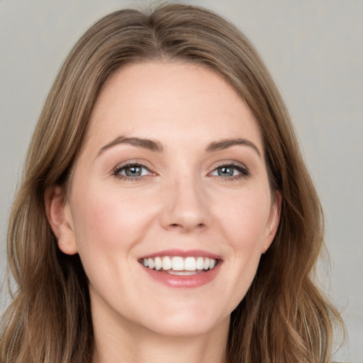 Joyful white young-adult female with long  brown hair and grey eyes