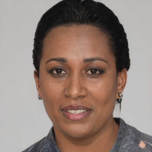 Joyful black young-adult female with short  black hair and brown eyes