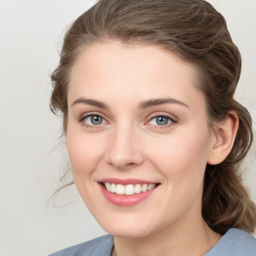 Joyful white young-adult female with medium  brown hair and green eyes