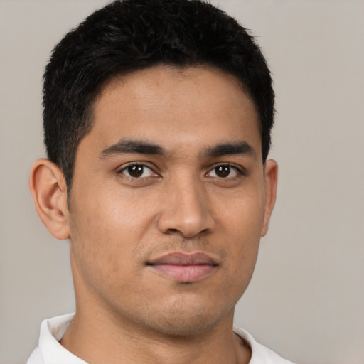 Joyful latino young-adult male with short  brown hair and brown eyes