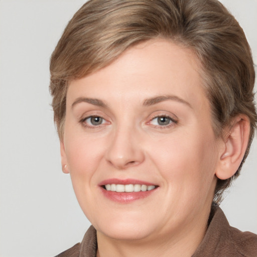 Joyful white adult female with medium  brown hair and grey eyes