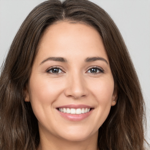 Joyful white young-adult female with long  brown hair and brown eyes