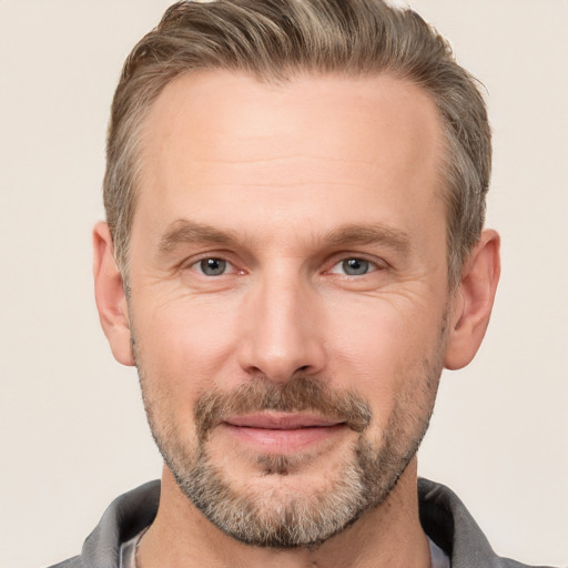 Joyful white adult male with short  brown hair and grey eyes