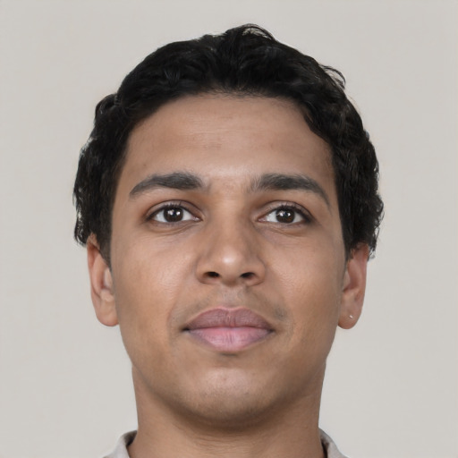 Joyful latino young-adult male with short  black hair and brown eyes