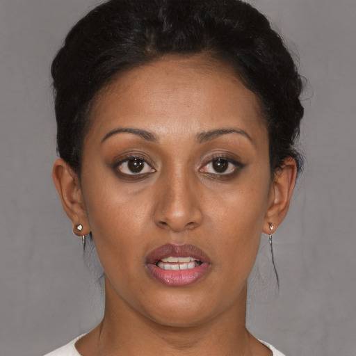 Joyful latino young-adult female with short  brown hair and brown eyes