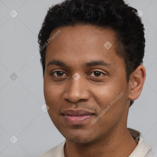 Joyful black young-adult male with short  black hair and brown eyes