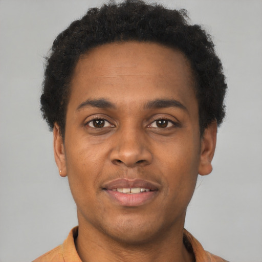 Joyful black young-adult male with short  brown hair and brown eyes