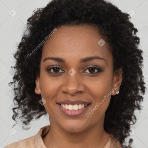 Joyful black young-adult female with long  brown hair and brown eyes