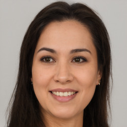 Joyful white young-adult female with long  brown hair and brown eyes