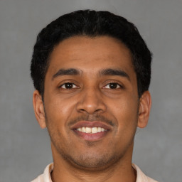 Joyful latino young-adult male with short  black hair and brown eyes