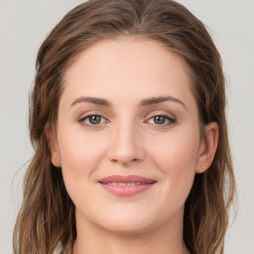 Joyful white young-adult female with long  brown hair and green eyes