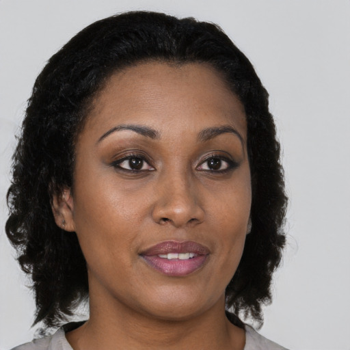 Joyful black young-adult female with medium  brown hair and brown eyes