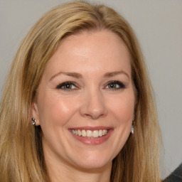 Joyful white adult female with long  brown hair and brown eyes