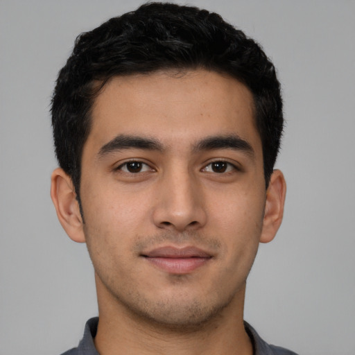 Joyful latino young-adult male with short  brown hair and brown eyes