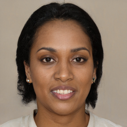 Joyful black young-adult female with medium  black hair and brown eyes