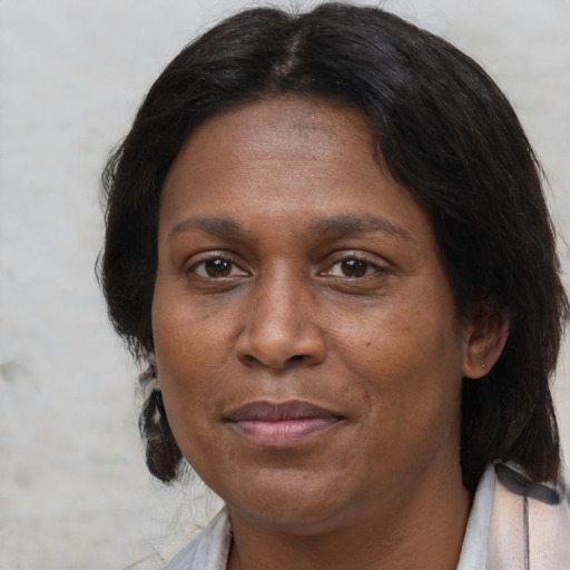 Joyful black adult female with medium  brown hair and brown eyes