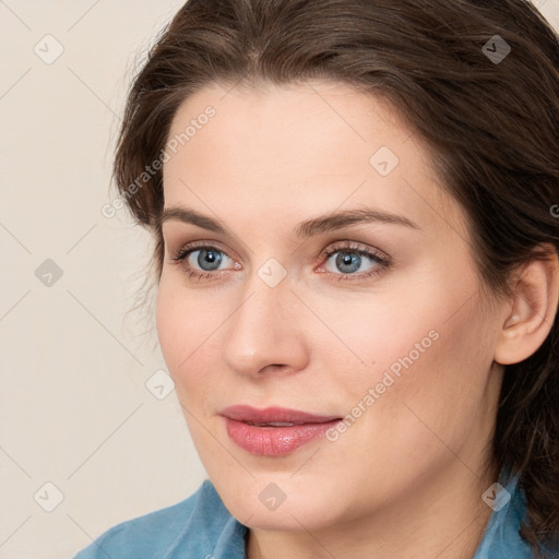 Joyful white young-adult female with long  brown hair and blue eyes