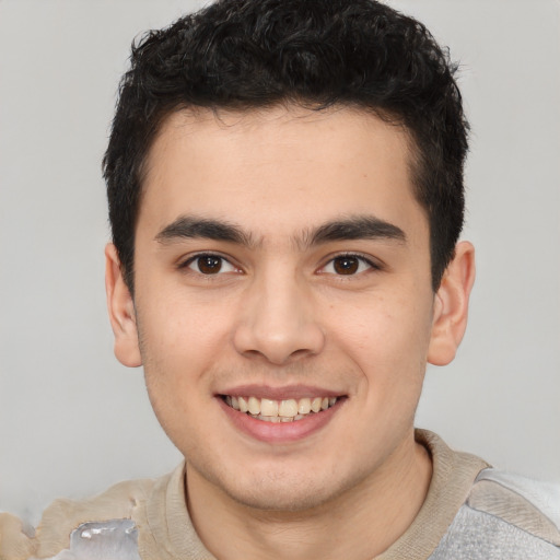 Joyful latino young-adult male with short  brown hair and brown eyes