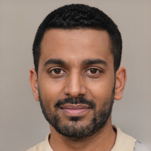 Joyful black young-adult male with short  black hair and brown eyes