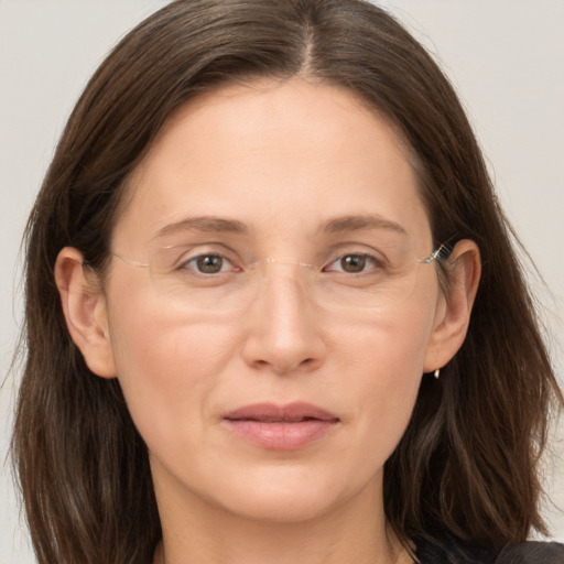 Joyful white adult female with long  brown hair and grey eyes