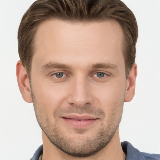 Joyful white young-adult male with short  brown hair and grey eyes