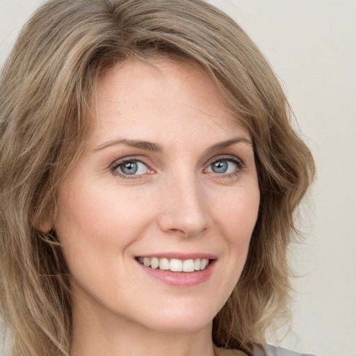 Joyful white young-adult female with long  brown hair and green eyes