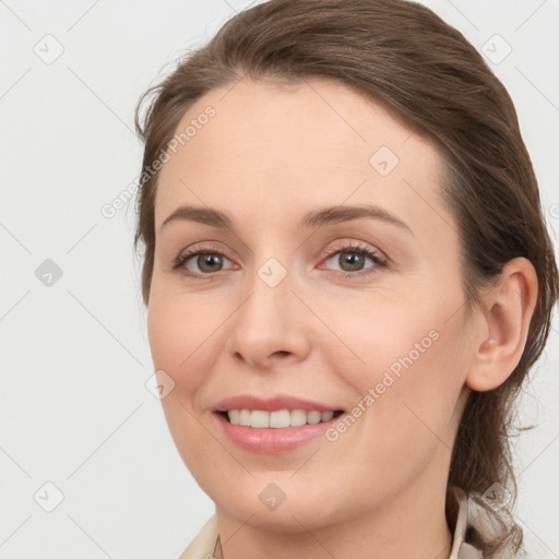 Joyful white young-adult female with medium  brown hair and grey eyes