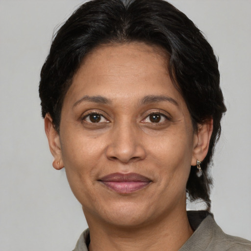 Joyful latino adult female with short  brown hair and brown eyes