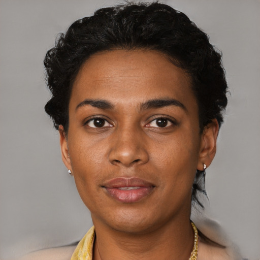 Joyful black young-adult female with short  black hair and brown eyes