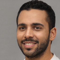 Joyful latino young-adult male with short  black hair and brown eyes