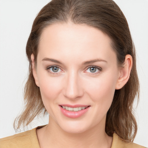 Joyful white young-adult female with medium  brown hair and grey eyes