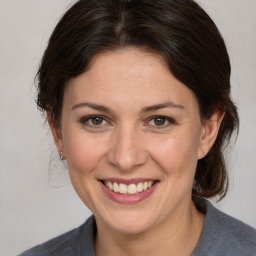 Joyful white adult female with medium  brown hair and grey eyes