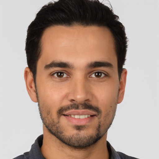 Joyful latino young-adult male with short  black hair and brown eyes