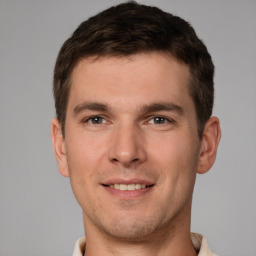 Joyful white young-adult male with short  brown hair and grey eyes